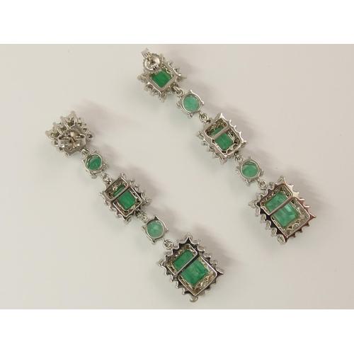 778 - A pair of long dangly diamond and emerald earrings