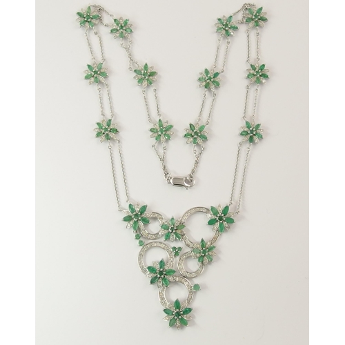 794A - A 14ct white gold substantial emerald and diamond flower necklace