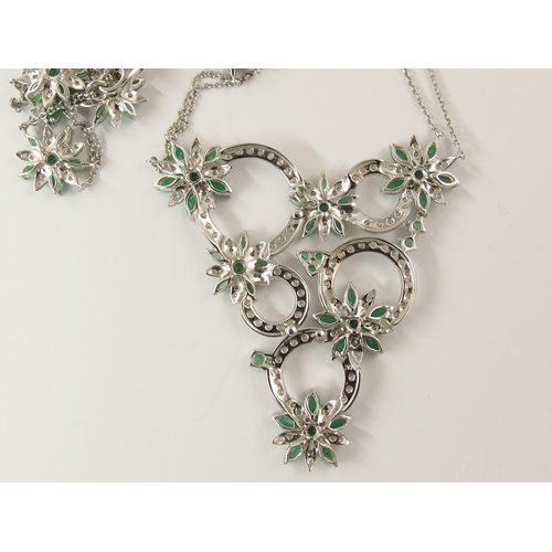 794A - A 14ct white gold substantial emerald and diamond flower necklace