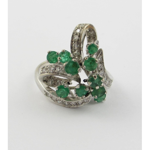 798 - An emerald and diamond cluster ring