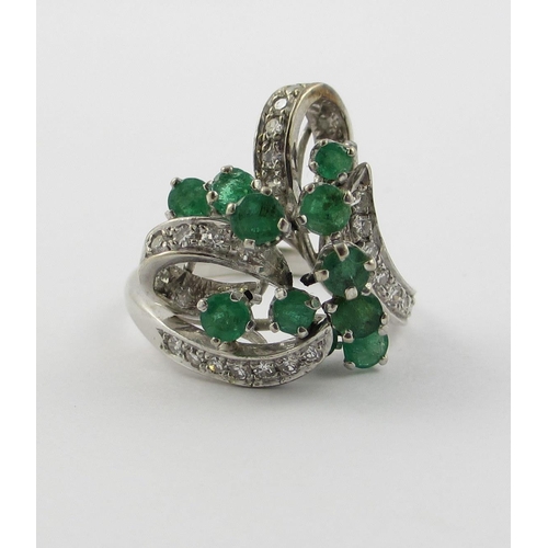 798 - An emerald and diamond cluster ring