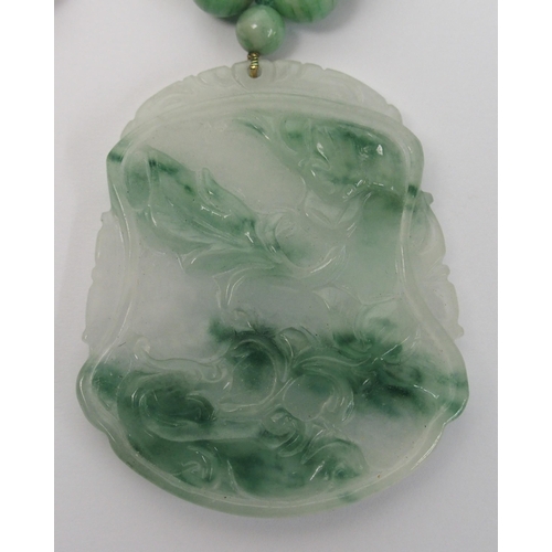 97 - A Chinese green hardstone pendant necklace