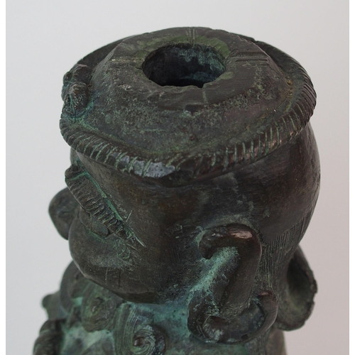 62 - A Chinese bronze figure of a Guardian standing on a drum