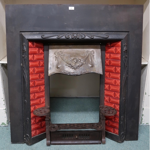 17 - A Victorian Arts & Crafts cast iron fire insert with red tiled sides over cast iron grill, 107cm... 