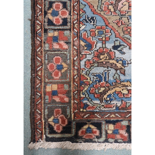33 - A beige ground Hamadan rug with red central medallion, blue spandrels and dark borders, 193cm long x... 