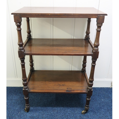 39 - A Victorian mahogany three tier what-not with turned uprights on brass casters, 111cm high x 76cm wi... 