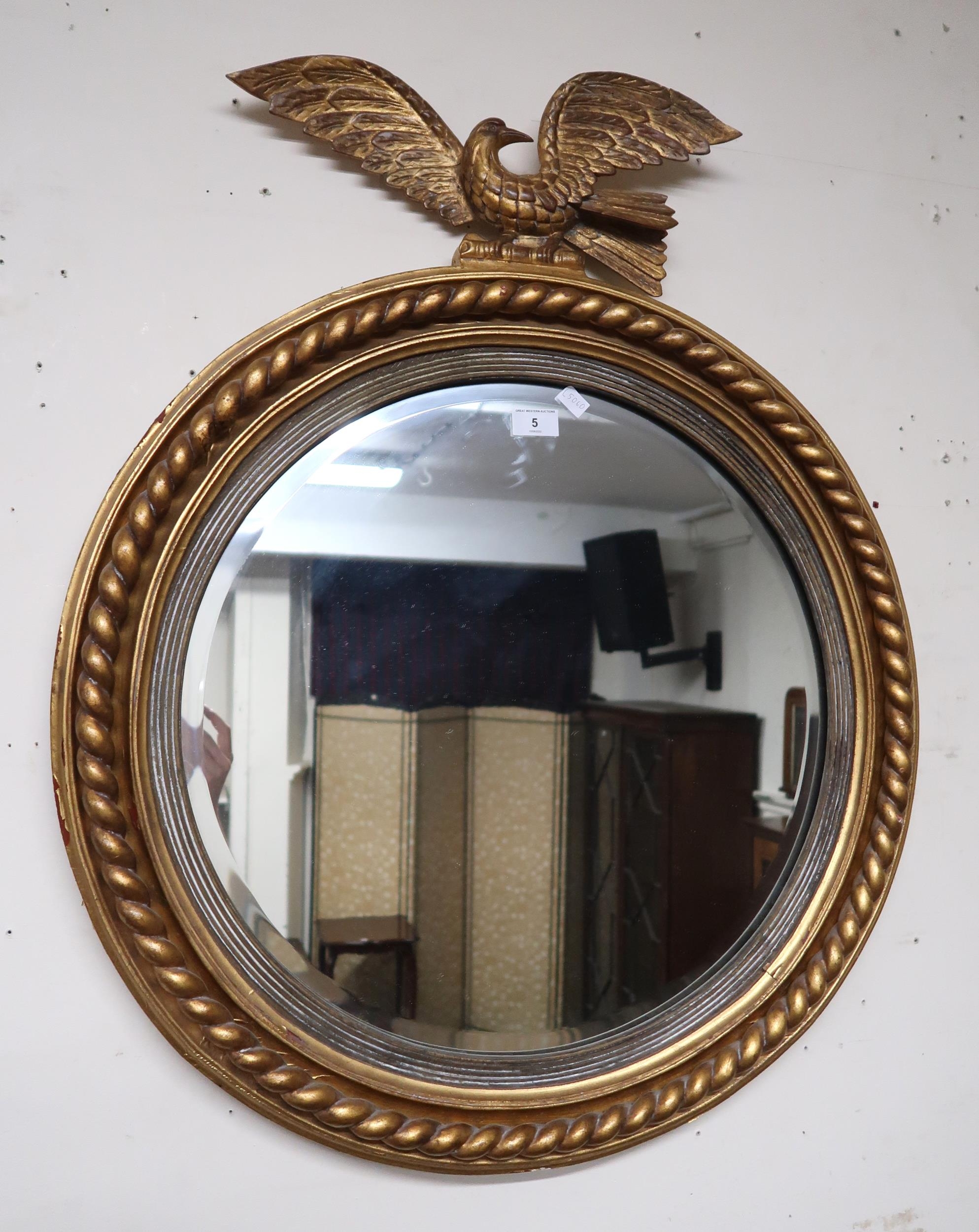 A 20th century gilt framed circular wall mirror with eagle s...