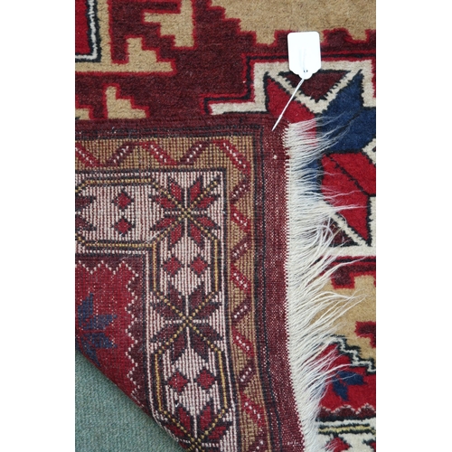 52 - A red ground geometric pattern rug with three medallions and cream borders, 182cm high x 104cm wide