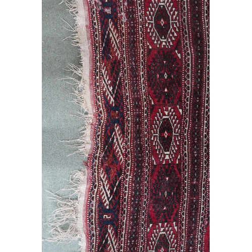 61 - A large red ground Bokhara rug with all over lozenge design, 370cm long x 232cm wide