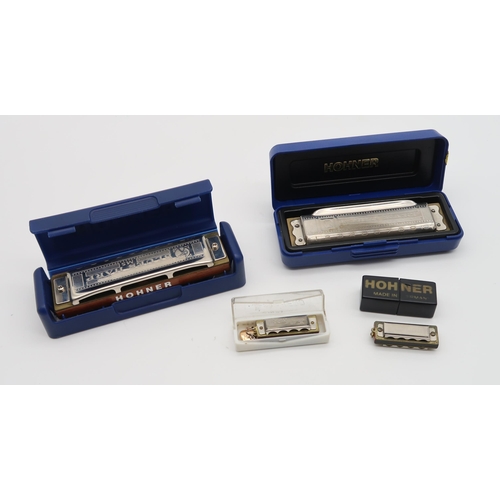 602 - A lot comprising two Hohner blues harps in D, a Hohner Little Lady harmonica and a Hero harmonica.