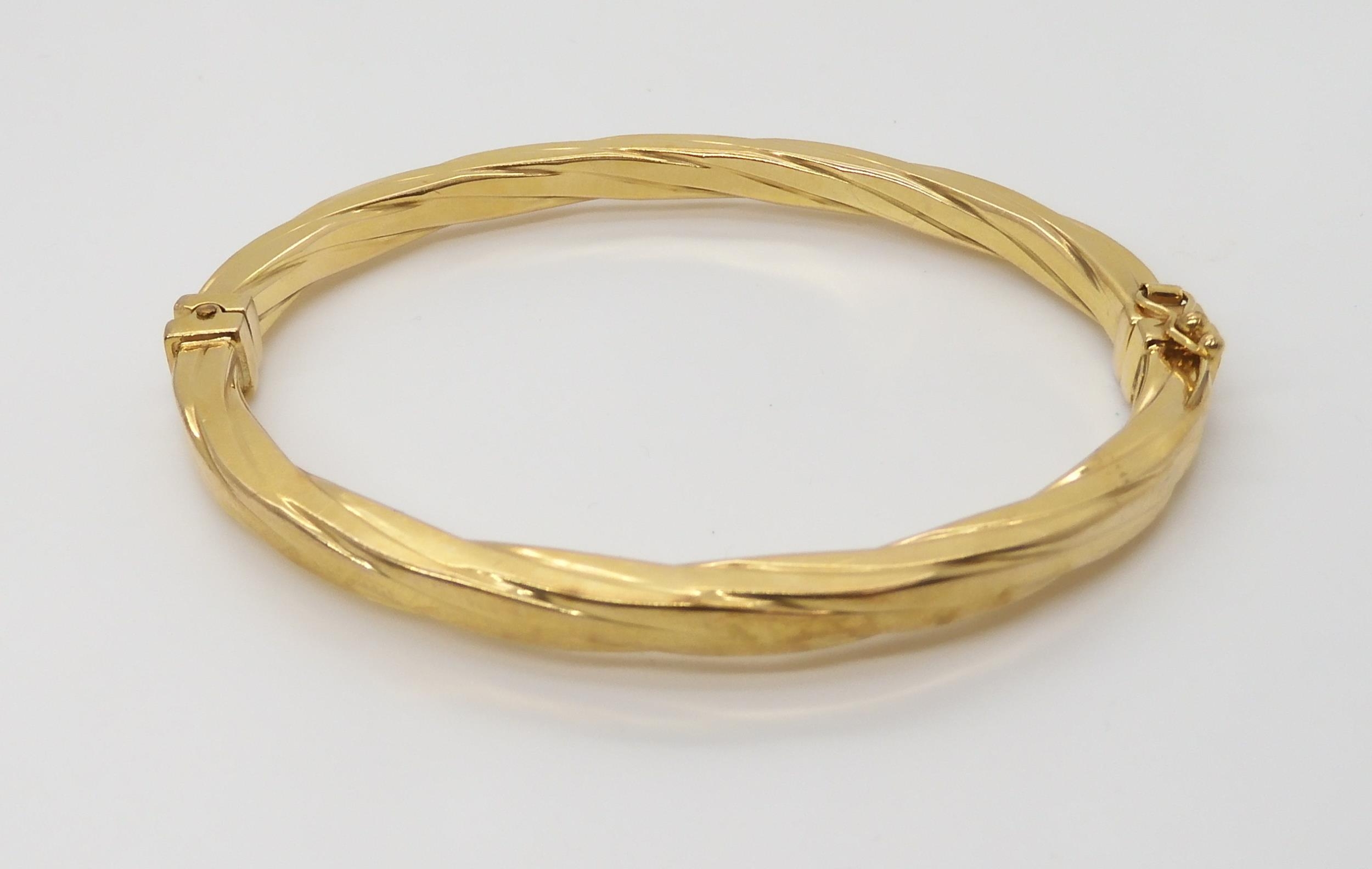 An Italian made 9ct gold bangle, inner diameters 6cm x 4.9cm ...