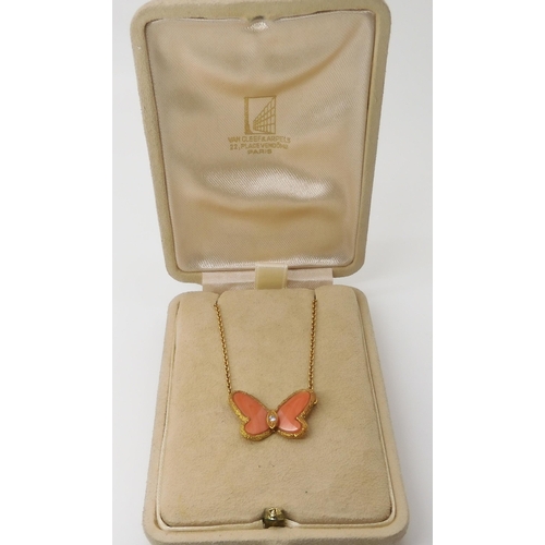 654 - A VAN CLEEF & ARPELS CORAL BUTTERFLY NECKLETthe body set with a diamond, the wings set with cora... 