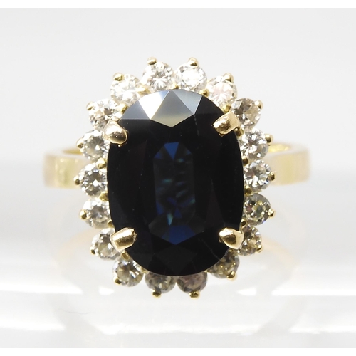 665 - A SAPPHIRE AND DIAMOND CLUSTER RINGmounted in 18ct gold, the sapphire is approx 12.5mm x 9.1mm x 4.4... 