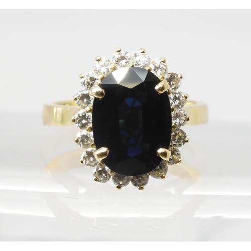 665 - A SAPPHIRE AND DIAMOND CLUSTER RINGmounted in 18ct gold, the sapphire is approx 12.5mm x 9.1mm x 4.4... 