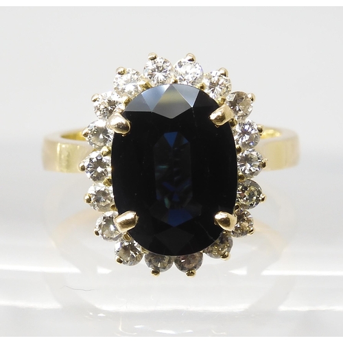 665 - A SAPPHIRE AND DIAMOND CLUSTER RINGmounted in 18ct gold, the sapphire is approx 12.5mm x 9.1mm x 4.4... 