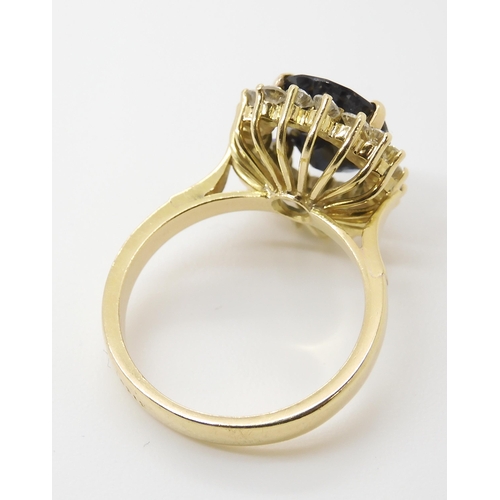 665 - A SAPPHIRE AND DIAMOND CLUSTER RINGmounted in 18ct gold, the sapphire is approx 12.5mm x 9.1mm x 4.4... 