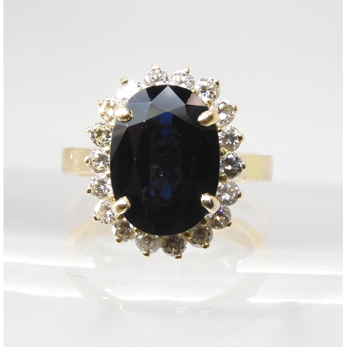 665 - A SAPPHIRE AND DIAMOND CLUSTER RINGmounted in 18ct gold, the sapphire is approx 12.5mm x 9.1mm x 4.4... 