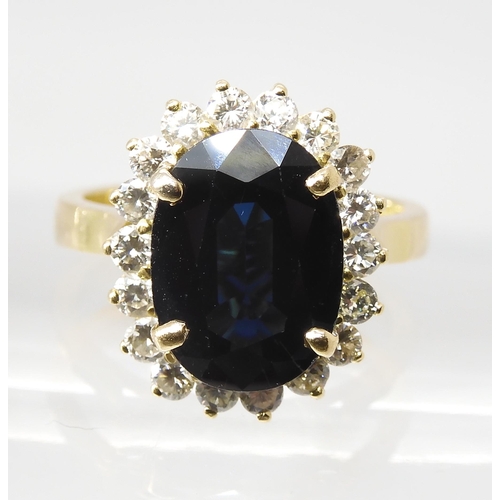 665 - A SAPPHIRE AND DIAMOND CLUSTER RINGmounted in 18ct gold, the sapphire is approx 12.5mm x 9.1mm x 4.4... 