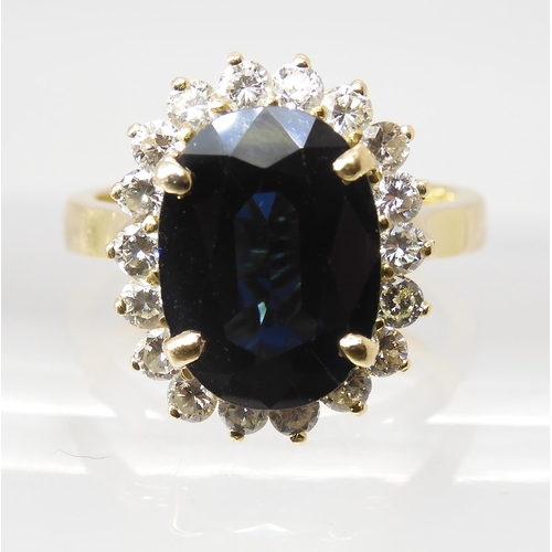 665 - A SAPPHIRE AND DIAMOND CLUSTER RINGmounted in 18ct gold, the sapphire is approx 12.5mm x 9.1mm x 4.4... 