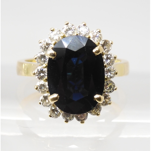 665 - A SAPPHIRE AND DIAMOND CLUSTER RINGmounted in 18ct gold, the sapphire is approx 12.5mm x 9.1mm x 4.4... 