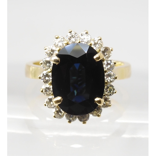 665 - A SAPPHIRE AND DIAMOND CLUSTER RINGmounted in 18ct gold, the sapphire is approx 12.5mm x 9.1mm x 4.4... 