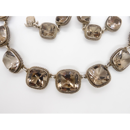 671 - A SMOKEY QUARTZ RIVERA NECKLACEthe cushion cut smokey quartz are set throughout in white metal, with... 