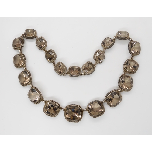 671 - A SMOKEY QUARTZ RIVERA NECKLACEthe cushion cut smokey quartz are set throughout in white metal, with... 