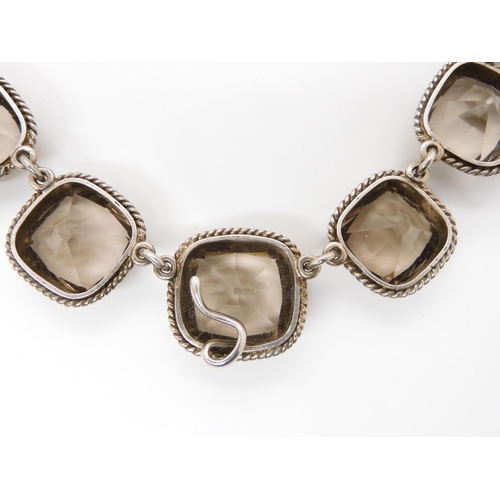 671 - A SMOKEY QUARTZ RIVERA NECKLACEthe cushion cut smokey quartz are set throughout in white metal, with... 