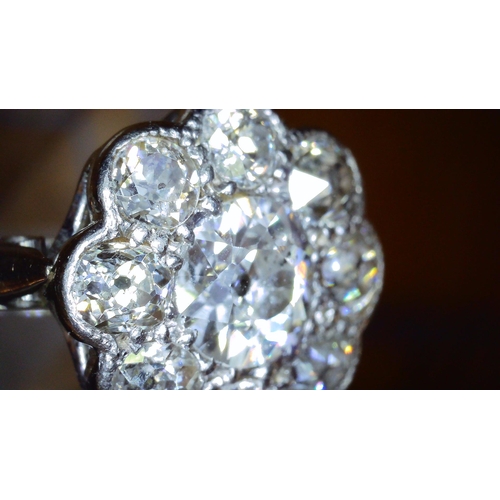 690 - AN OLD CUT DIAMOND FLOWER RINGmounted throughout in 18ct white gold and platinum, the central diamon... 