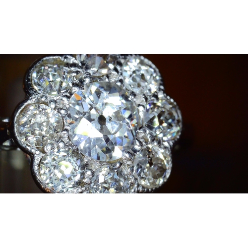 690 - AN OLD CUT DIAMOND FLOWER RINGmounted throughout in 18ct white gold and platinum, the central diamon... 