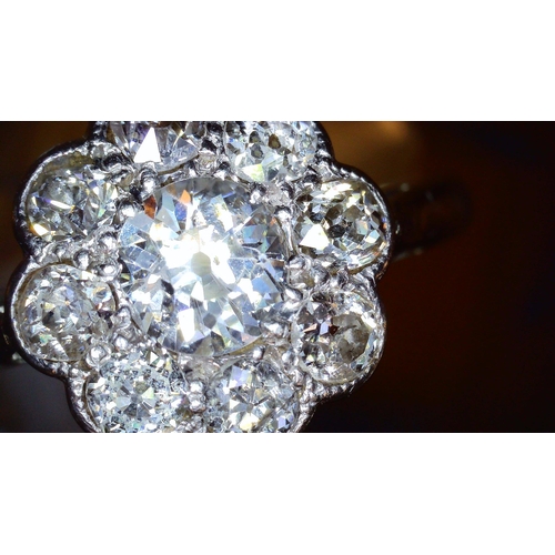 690 - AN OLD CUT DIAMOND FLOWER RINGmounted throughout in 18ct white gold and platinum, the central diamon... 