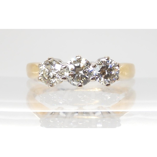 695 - AN 18CT GOLD THREE STONE DIAMOND RINGset throughout in yellow gold. The three diamonds together are ... 