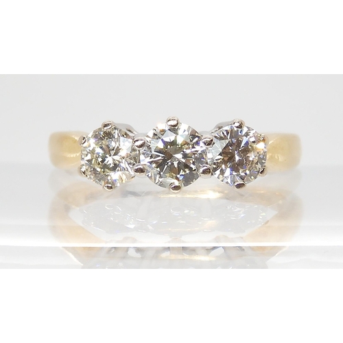 695 - AN 18CT GOLD THREE STONE DIAMOND RINGset throughout in yellow gold. The three diamonds together are ... 