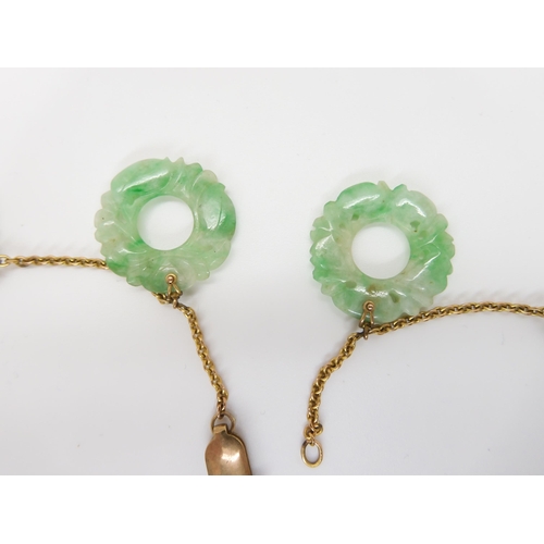 696 - A CHINESE GREEN HARDSTONE NECKLACEeach rondel is carved with foliage, (one is af) and attached to a ... 