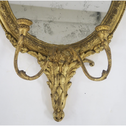 7 - A 19TH CENTURY GILT AND GESSO OVAL GIRANDOLE WALL MIRROR with two branch candle holder and floral an... 