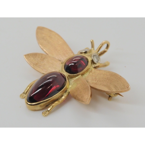 715 - A 9CT GOLD BEE BROOCHwith diamond eyes and the body set with garnets. Dimensions 3.8cm x 3.2cm, weig... 