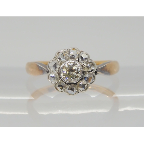 730 - A VINTAGE DIAMOND FLOWER RINGin a yellow and white metal setting, the central old cut diamond is app... 