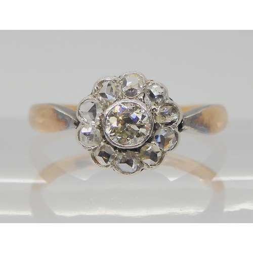 730 - A VINTAGE DIAMOND FLOWER RINGin a yellow and white metal setting, the central old cut diamond is app... 