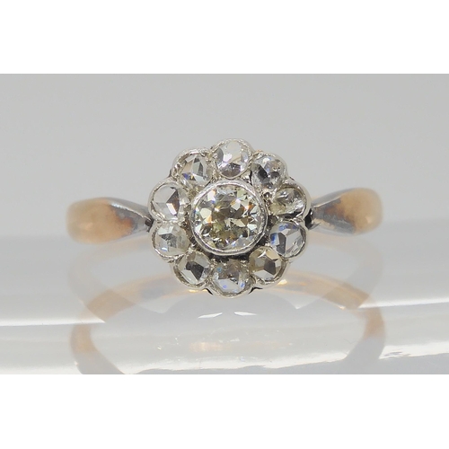 730 - A VINTAGE DIAMOND FLOWER RINGin a yellow and white metal setting, the central old cut diamond is app... 