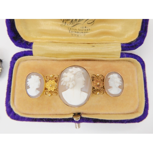 736 - THREE JEWELSa 15ct gold mounted triple cameo brooch with filigree and granulation details, largest c... 