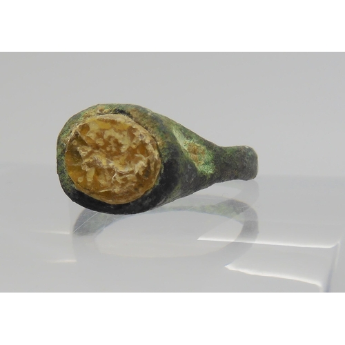 743 - AN OF THE ANTIQUE BRONZE RINGin excavated state, set with an engraved intaglio 'stone' possibly glas... 