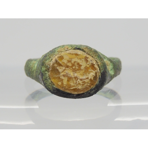 743 - AN OF THE ANTIQUE BRONZE RINGin excavated state, set with an engraved intaglio 'stone' possibly glas... 