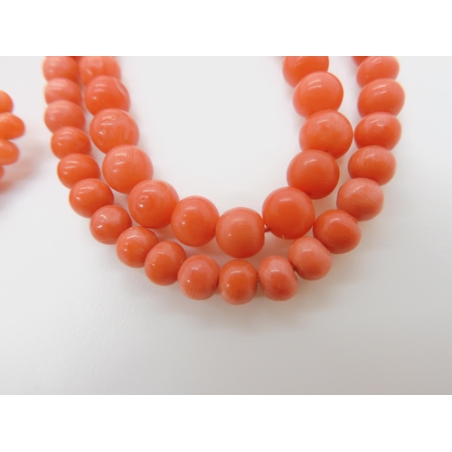 746 - TWO STRINGS OF CORAL BEADSa double string of tapered coral beads, largest bead approx 6mm, length of... 