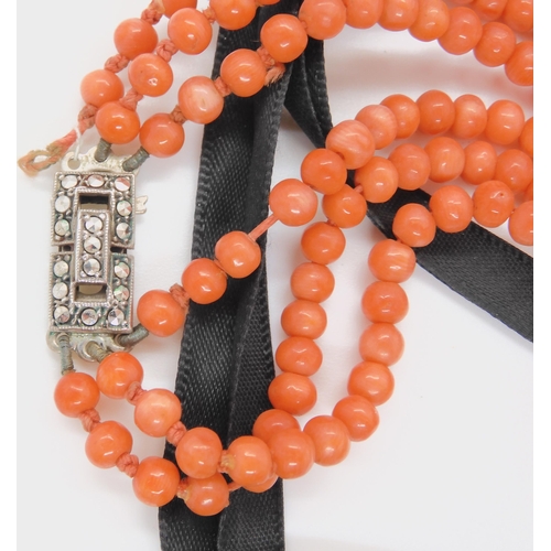 747 - CORAL STATEMENT BEADSa string of woven coral beads, with black glass beads and ribbon strap. Each wo... 