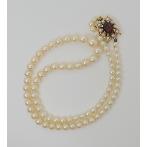 754 - A STRING OF PEARLS with a 9ct gold garnet and pearl clasp, stamped C&F for Cropp & Farr Ltd,... 