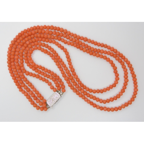 756 - A TRIPLE STRING OF CORAL BEADSall beads approx 5mm in diameter, shortest length 48cm, with a decorat... 