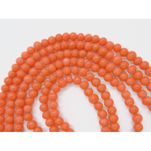 756 - A TRIPLE STRING OF CORAL BEADSall beads approx 5mm in diameter, shortest length 48cm, with a decorat... 