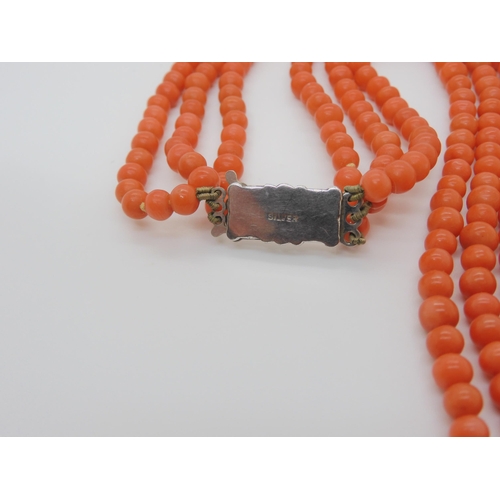 756 - A TRIPLE STRING OF CORAL BEADSall beads approx 5mm in diameter, shortest length 48cm, with a decorat... 