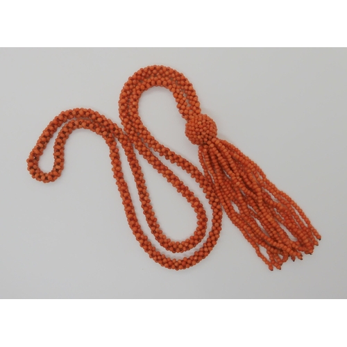 758 - A WOVEN CORAL BEAD NECKLACE WITH A TASSELlength of the necklace 74cm, length of tassel drop 11cm... 