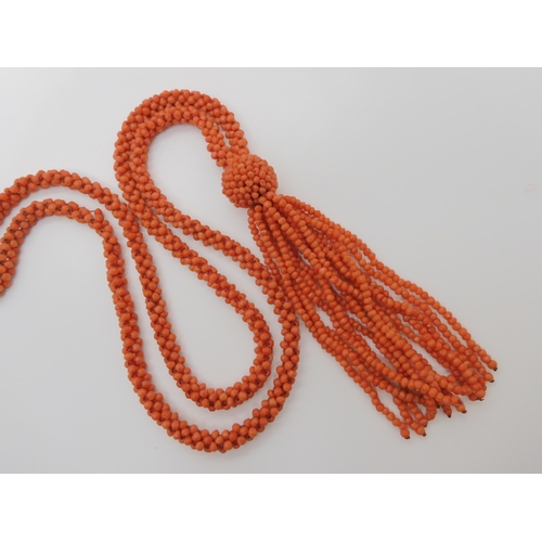 758 - A WOVEN CORAL BEAD NECKLACE WITH A TASSELlength of the necklace 74cm, length of tassel drop 11cm... 